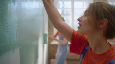 Kapalı alanda duvar boyayan mutlu çift. Ev onarımı sırasında aile dansı..