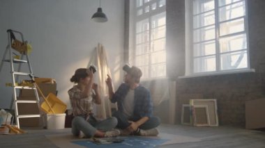 Evde video gözlüğü kullanan mutlu bir aile. Çift ev tasarımı hakkında konuşuyor..