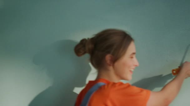Gülümseyen adam ve kadın yeni dairede duvarları boyuyor.. — Stok video