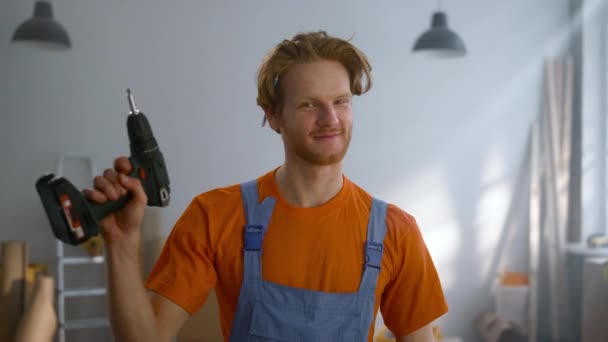 Hombre alegre posando con destornillador en nuevo apartamento durante la reparación del hogar. — Vídeos de Stock