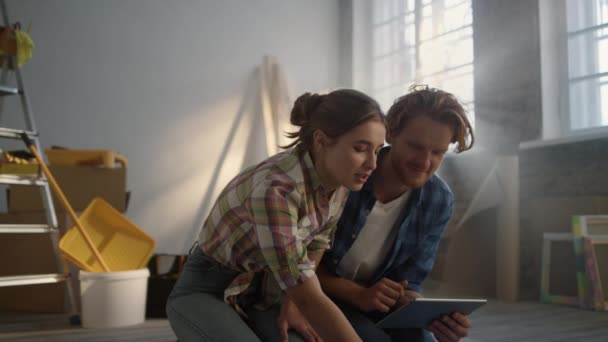 Joven sosteniendo la tableta adentro. Mujer feliz señalando planos en casa. — Vídeos de Stock