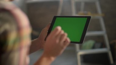 Bilinmeyen kız içeride tablet üzerinde çalışıyor. Onarım fikirlerini internetten arayan kadın.