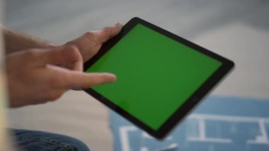 Ev tadilatı sırasında tablet kullanan tanınmamış kişiler. Tableti tutan adam..
