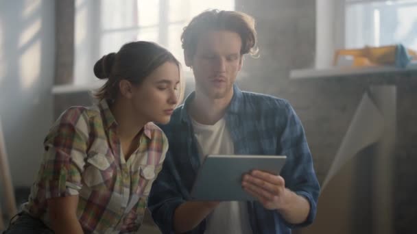 Casal feliz discutindo ideias de design dentro de casa. Mulher apontando para tela do tablet. — Vídeo de Stock