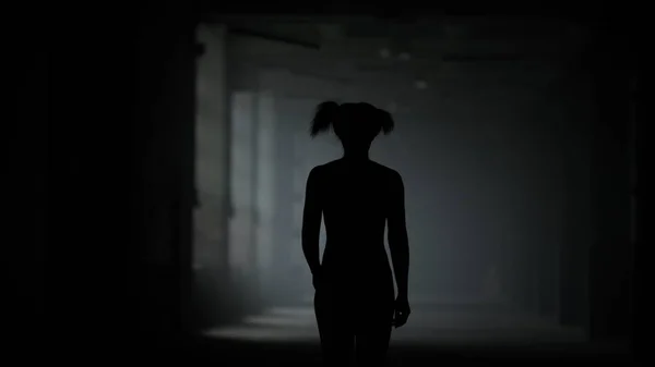 Atleta mujer caminando por el pasillo. Deportiva mujer ir en oscuro loft edificio — Foto de Stock