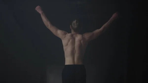 Bodybuilder loopt in donker gebouw. Man warming lichaam voor intensiteit training — Stockfoto
