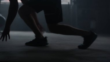 Atlet başlangıç pozisyonunda duruyor. Sporcu bacakları spor salonunda hızlı koşuyor.