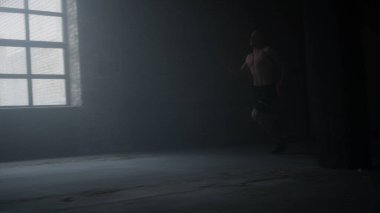 Çatı katında enerjik bir adam hızla koşuyor. Spor kulübünde koşan erkek koşucu