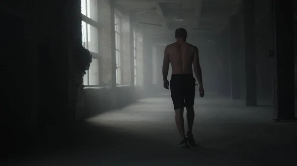 Muscular athlete walking in crossfit gym. Man going in sport club for training — Stock Photo, Image