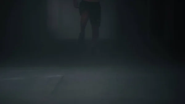 Fiziksel egzersiz yapan aktif bir sporcu. Erkek koşucu karanlık koridorda koşuyor — Stok fotoğraf