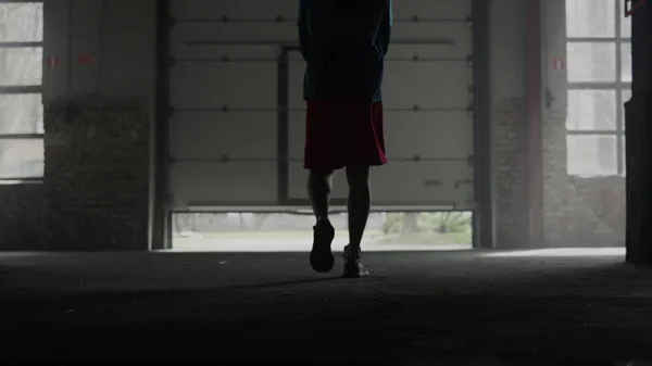 Hombre deportivo caminando en el gimnasio moderno. Tipo abriendo puertas de chapa en edificio loft —  Fotos de Stock