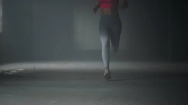 ジムで速く走るアスリートの足。ロフトビルで心臓のトレーニングをしてる女 — ストック写真
