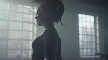 Sporcu kadın ip atlamakla kardiyo çalışması yapıyor. İp atlayan kız