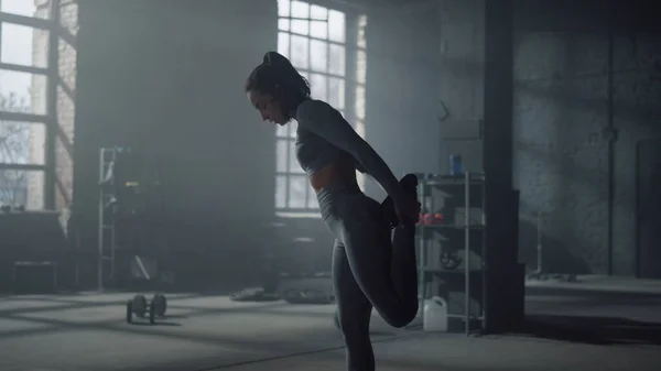 Sportvrouw die benen strekt voor de training. Meisje opwarming spieren in de sportschool — Stockfoto