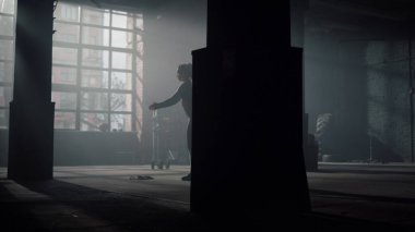 Modern spor salonunda çömelmiş bir kız. Dişi sporcu hamlelerle çömelme hareketi yapıyor.