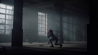 Vücut geliştirici Crossfit egzersizi yapıyor. Sportif kadın hamlelerle çömelme yapıyor.