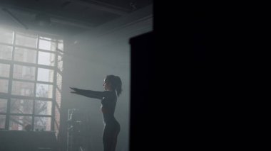 Beden eğitimi için hazırlanan bir kadın. Eğitimden önce vücudunu esneten kız