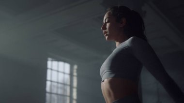 Bir kadın beden eğitimi dersinden önce vücudunu esnetiyor. Kız el kaldırıyor.