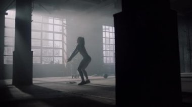 Spor salonunda çömelip zıplayan bir kız. Spor kulübüne çömelmiş enerjik bir kadın