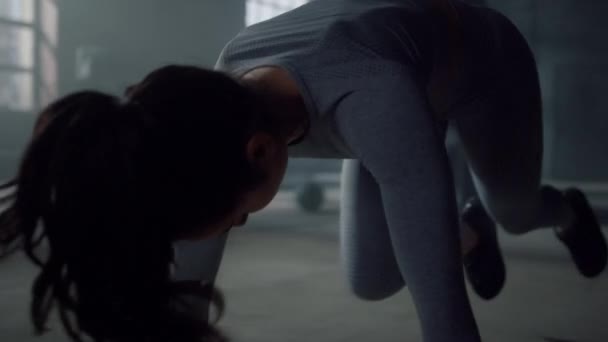 Женщина отжимается на полу в спортзале. Бодибилдер делает упражнения по кроссфиту — стоковое видео