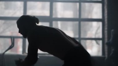 Spor salonunda koşan aktif bir adam. Üstsüz erkek koşucu kardiyo çalışması yapıyor. 