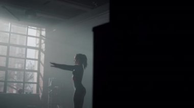 Beden eğitimi için hazırlanan bir kadın. Eğitimden önce vücudunu esneten kız