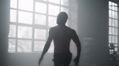 Spor salonunda kardiyo çalışması yapan bir sporcu. Çatı katında koşan sporcu