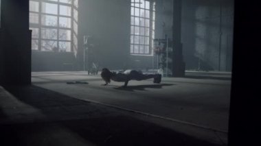 Spor salonunda spor müsabakası yapan bir kadın. Kadın sporcu yerde şınav çekiyor.