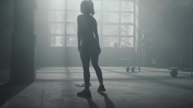 Beden eğitimi sırasında hamlelerle çömelen bir kadın. Kız bacak egzersizi yapıyor