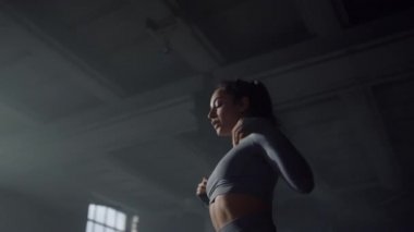 Kız vücudunu güç egzersizleri için hazırlıyor. Omuzları ısıtan vücut geliştirici 