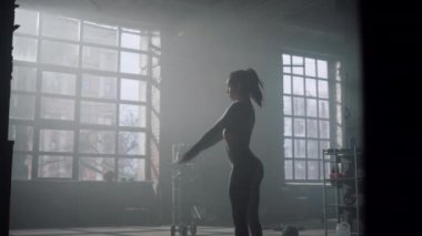 Eğitimden sonra elleri ısıtan vücut geliştirici. Çalışmadan önce ellerini hareket ettiren kadın