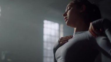 Sporcu kadın antrenmandan önce omuzlarını ısıtıyor. Formda kadın geriliyor. 