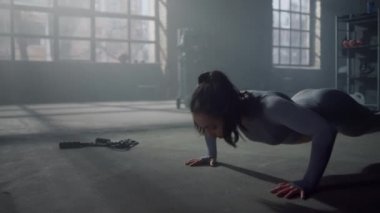 Tahtada duran bir kadın. Spor kulübünde şınav çeken atletik kız.