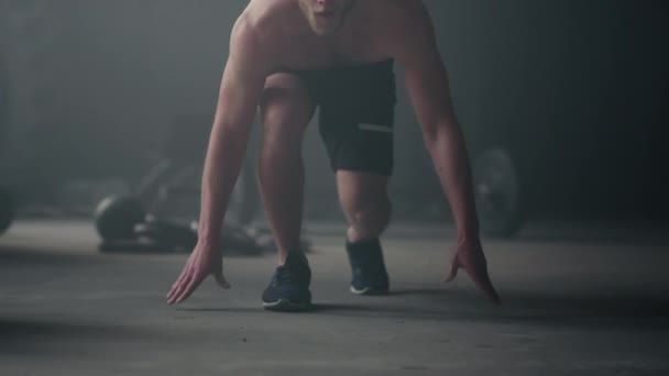 Hombre de fitness en posición de salida. Masculino jogger piernas corriendo en deporte club — Vídeo de stock