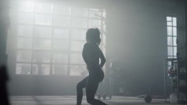 Sporcu kadın atlama egzersizi yapıyor. Fitness kızı hamle egzersizi yapıyor.