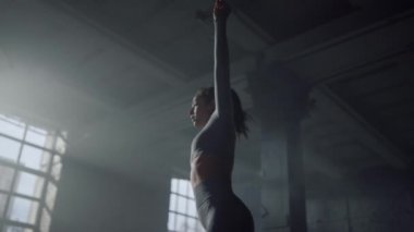 Sporcu kadın antrenmandan önce geriliyor. Egzersiz için kasları ısıtan kız.