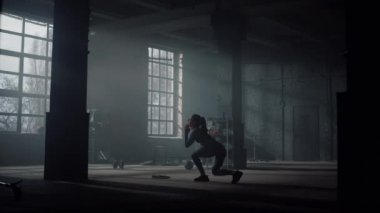 Vücut geliştirici Crossfit egzersizi yapıyor. Sportif kadın hamlelerle çömelme yapıyor.