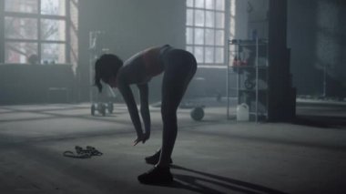 Spor salonunda eğilirken öne eğilen bir kadın. Vücut geliştiren fitness kızı. 