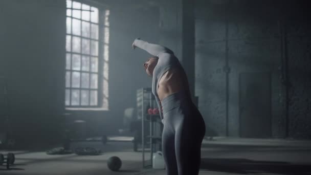 Mujer estirándose hacia atrás antes del entrenamiento cardiovascular. Cuerpo de calentamiento del atleta en el club deportivo — Vídeo de stock