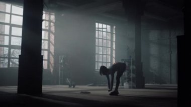 Spor giyim sektöründe kıvrımlar yapan aktif bir kız. Esnek kadın kaslarını ısıtıyor.