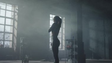 Antrenmandan önce boynunu ısıtan kız. Kadın vücut geliştirici, vücudu eğitime hazırlıyor.