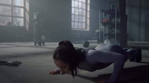 Женщина отжимается на полу в спортзале. Культурист делает фитнес-упражнения на доске — стоковое видео