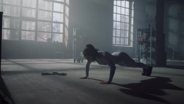 Женщина отжимается на полу в спортзале. Тренировка мышц брюшной полости — стоковое видео