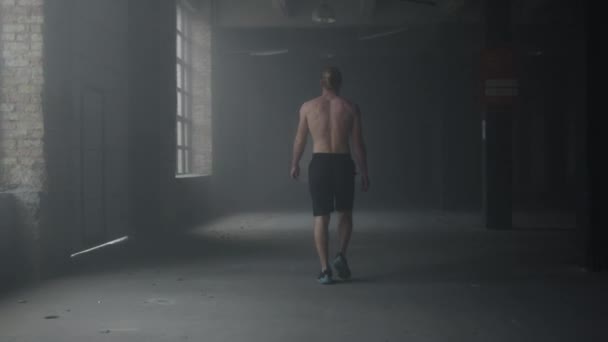 Man walking in building after workout. Athlete warming hands before training — Stock Video