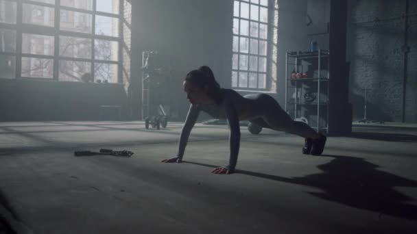 A sportoló fekvőtámaszt csinál a tornateremben. Fitnessz tréninget tartó nő a tetőtérben — Stock videók