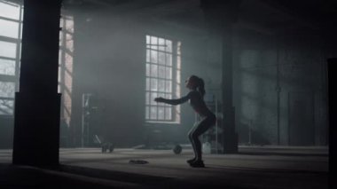 Çömelme hareketleri yapan bir kadın. Sportif kız antrenman sırasında mekik çekiyor.