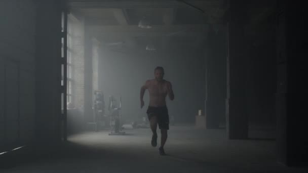 Sporty man starting to run in gym. Guy warming body before crossfit exercise — Stock Video