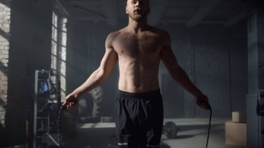 Atlayan bir atlet ip atlıyor. Adam atlama halatıyla kardiyo çalışması yapıyor.