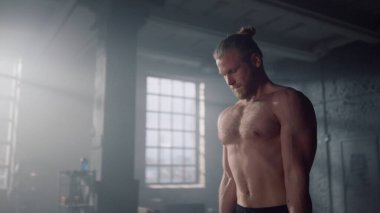 Spor salonunda pazı kasları üzerinde egzersiz yapan bir adam. Eğitimde çığlık atan adam 