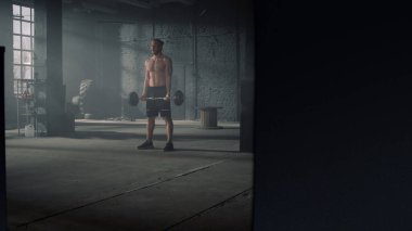 Powerlifter geniş tutuş biceps kıvrım egzersizi yapıyor. Adam kol kaslarını şişiriyor.